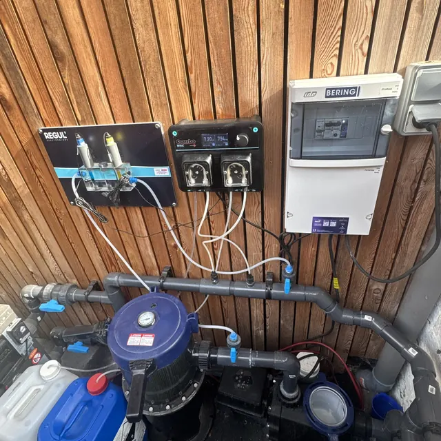 Combo et chambre d'analyse Régul' sur un bardage bois, au-dessus de la pompe de filtration